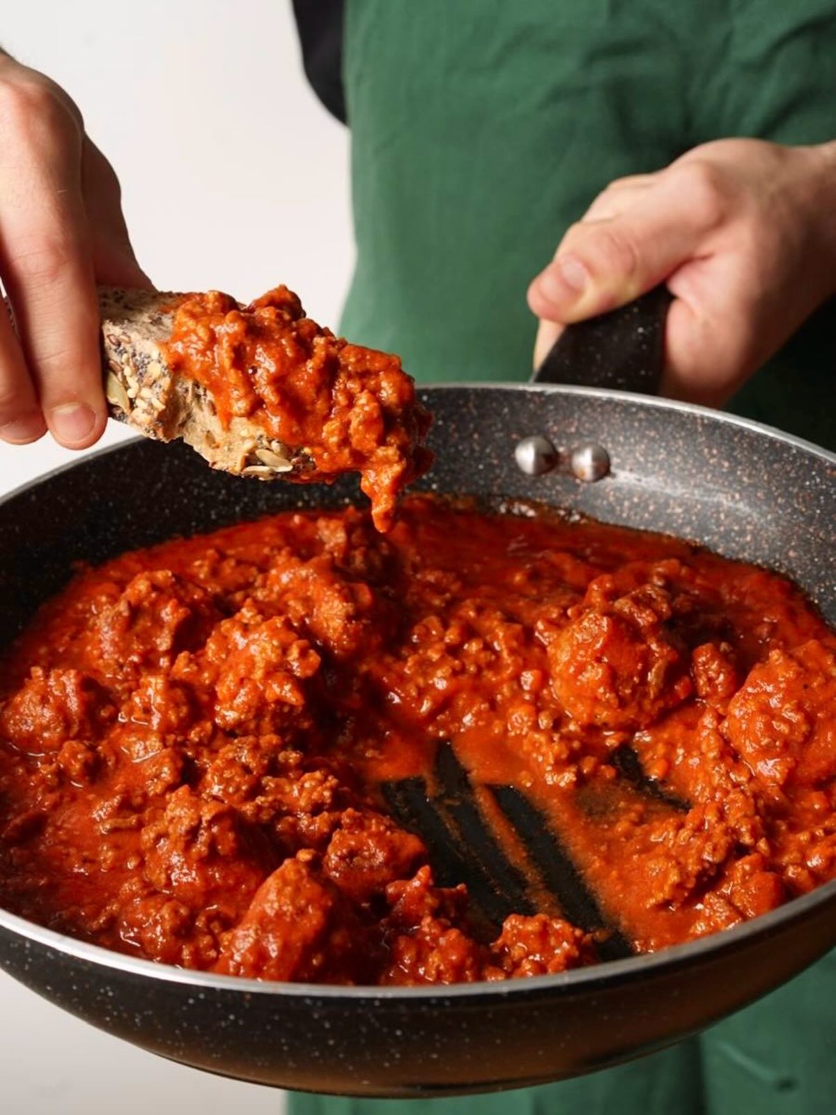 Mopping rich sauce with crusty bread from skillet